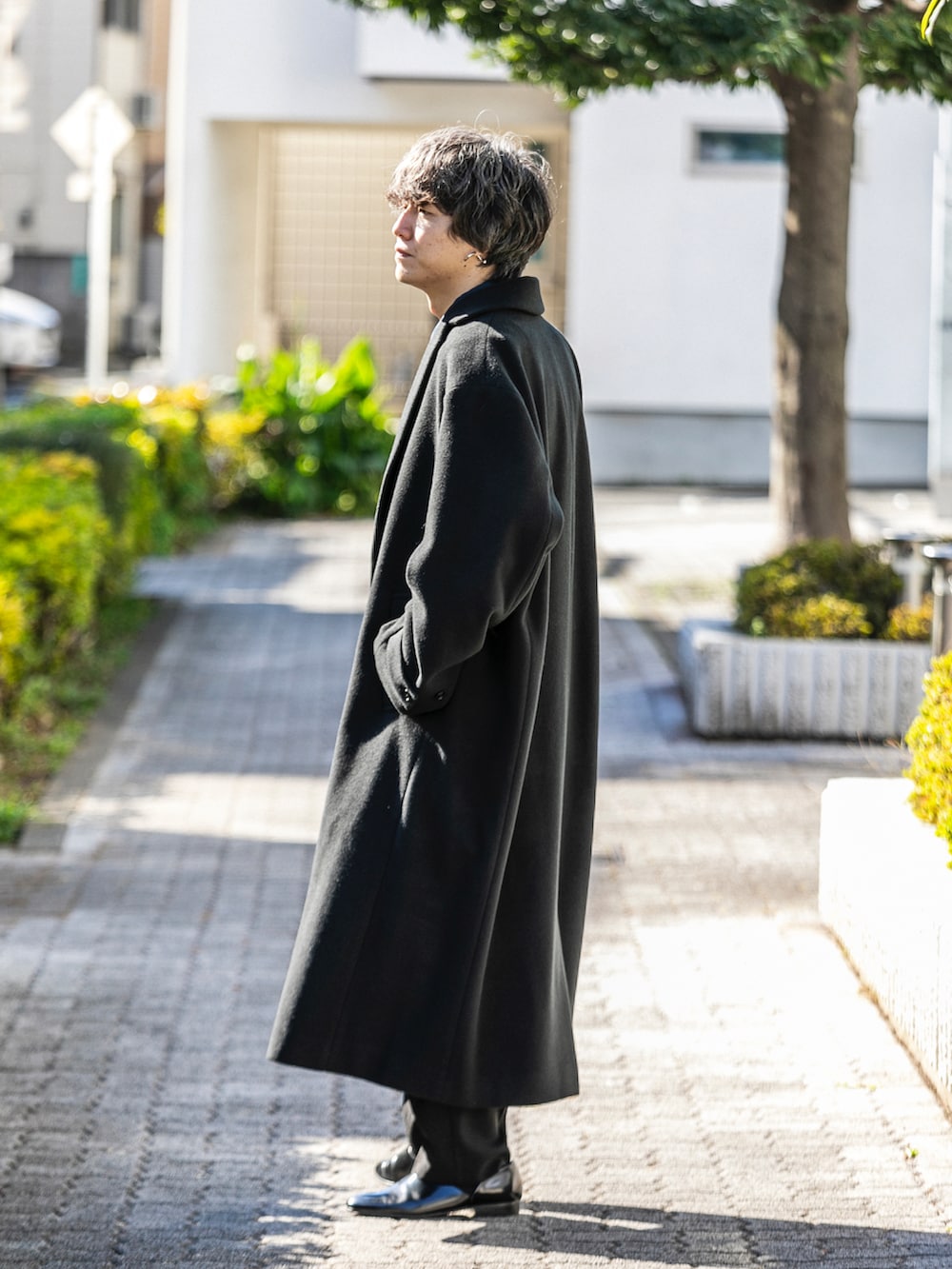 ブラック系のチェスターコート、ブラック系のその他パンツ、ブラック系のシューズを着用したメンズの冬コーディネートの3枚目の写真