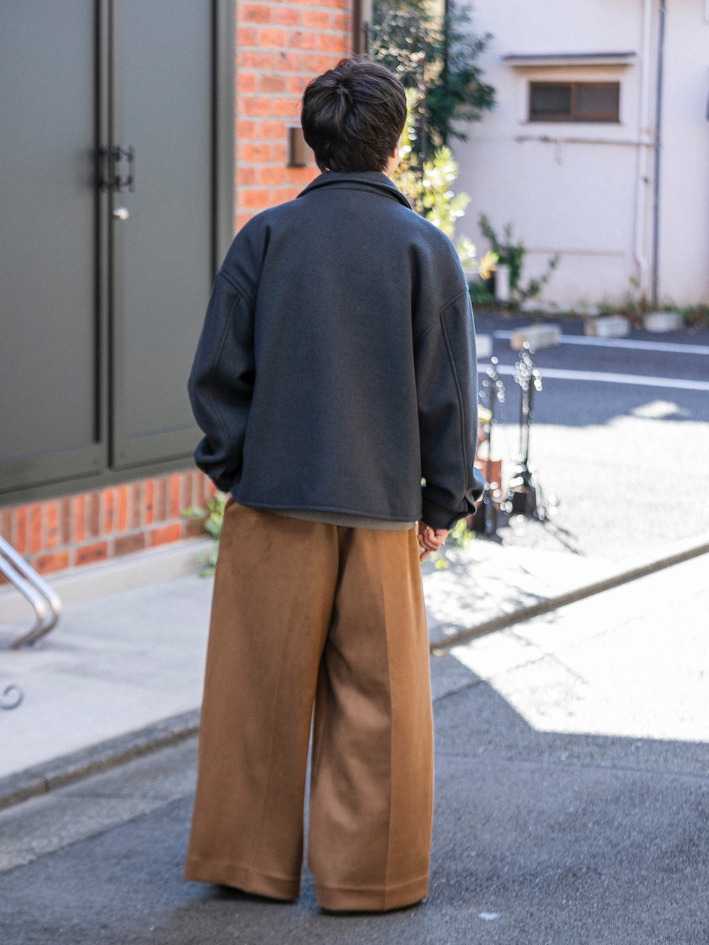 ブラック系のブルゾン、ベージュ系のニット/セーター、ベージュ系のその他パンツを着用したメンズの冬コーディネートの3枚目の写真