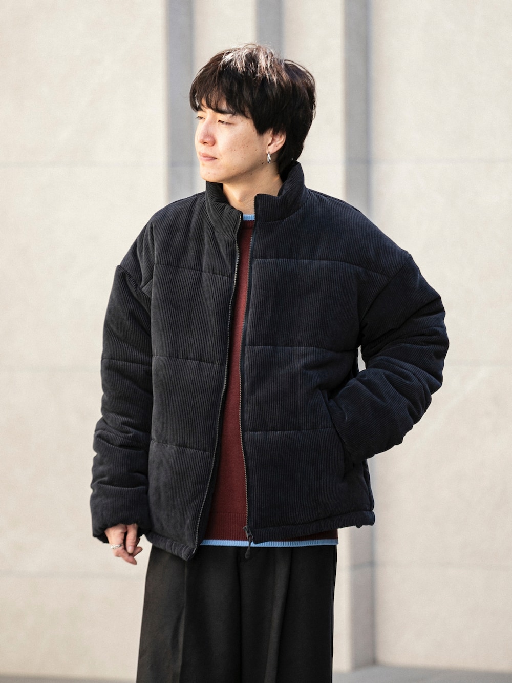 ブラック系のダウンジャケット/コート、ホワイト系のニット/セーター、ブラック系のその他パンツを着用したメンズの冬コーディネートの4枚目の写真