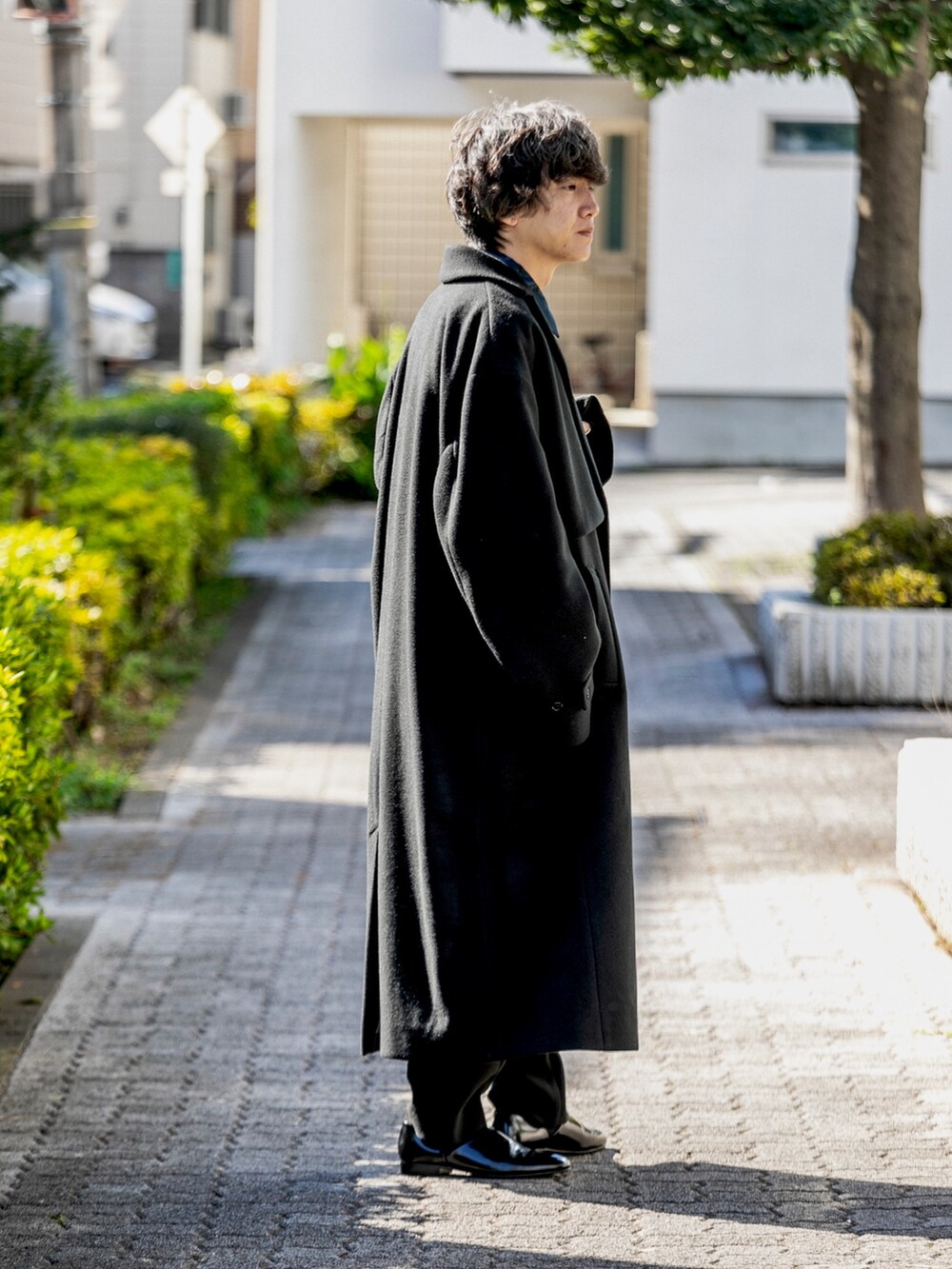 ブラック系のチェスターコート、ブルー系のシャツ/ブラウス、ブラック系のその他パンツを着用したメンズの秋コーディネートの3枚目の写真