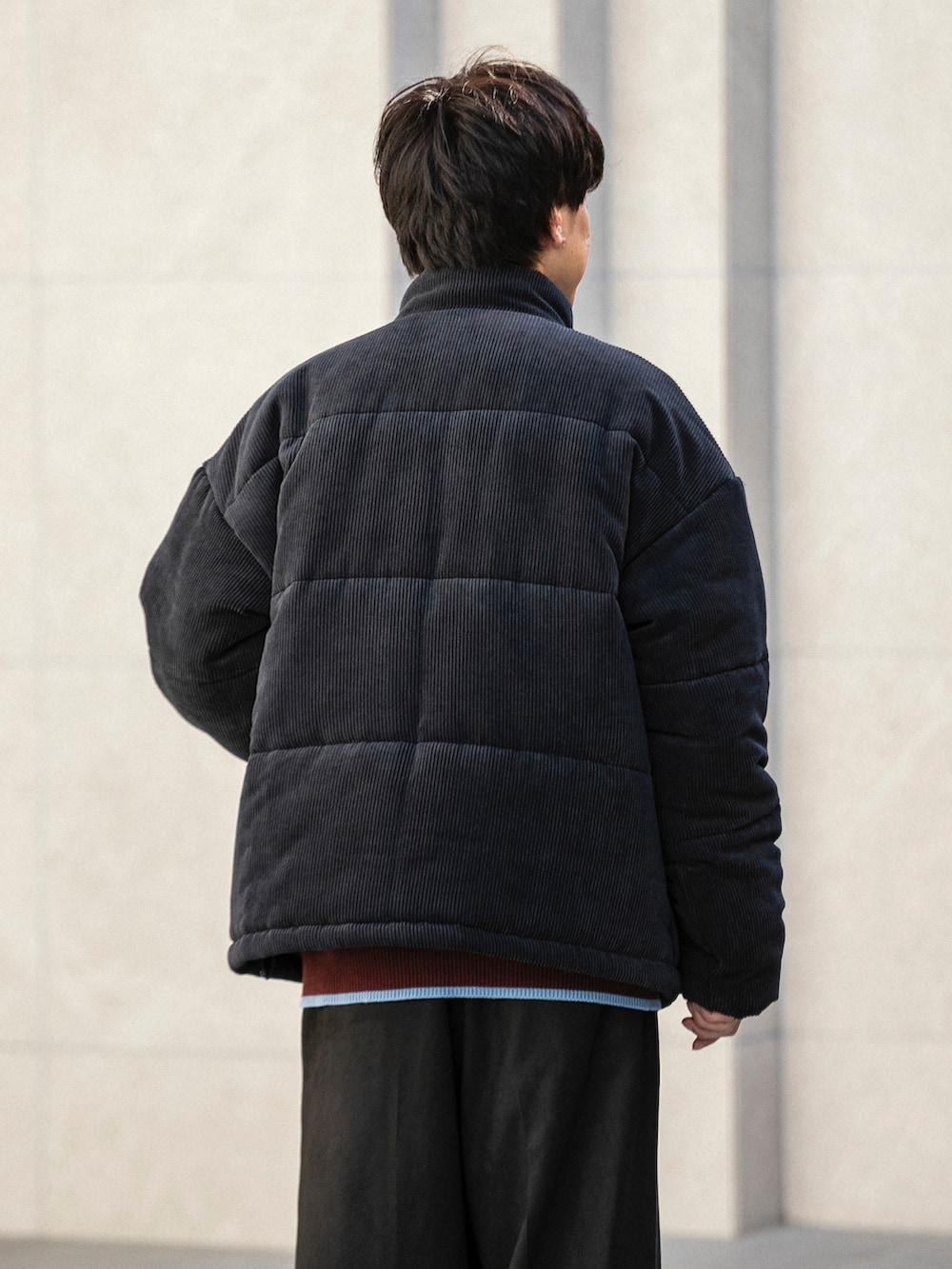 ブラック系のダウンジャケット/コート、ホワイト系のニット/セーター、ブラック系のその他パンツを着用したメンズの冬コーディネートの5枚目の写真