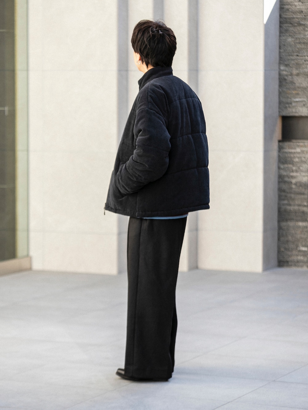 ブラック系のダウンジャケット/コート、ホワイト系のニット/セーター、ブラック系のその他パンツを着用したメンズの冬コーディネートの2枚目の写真