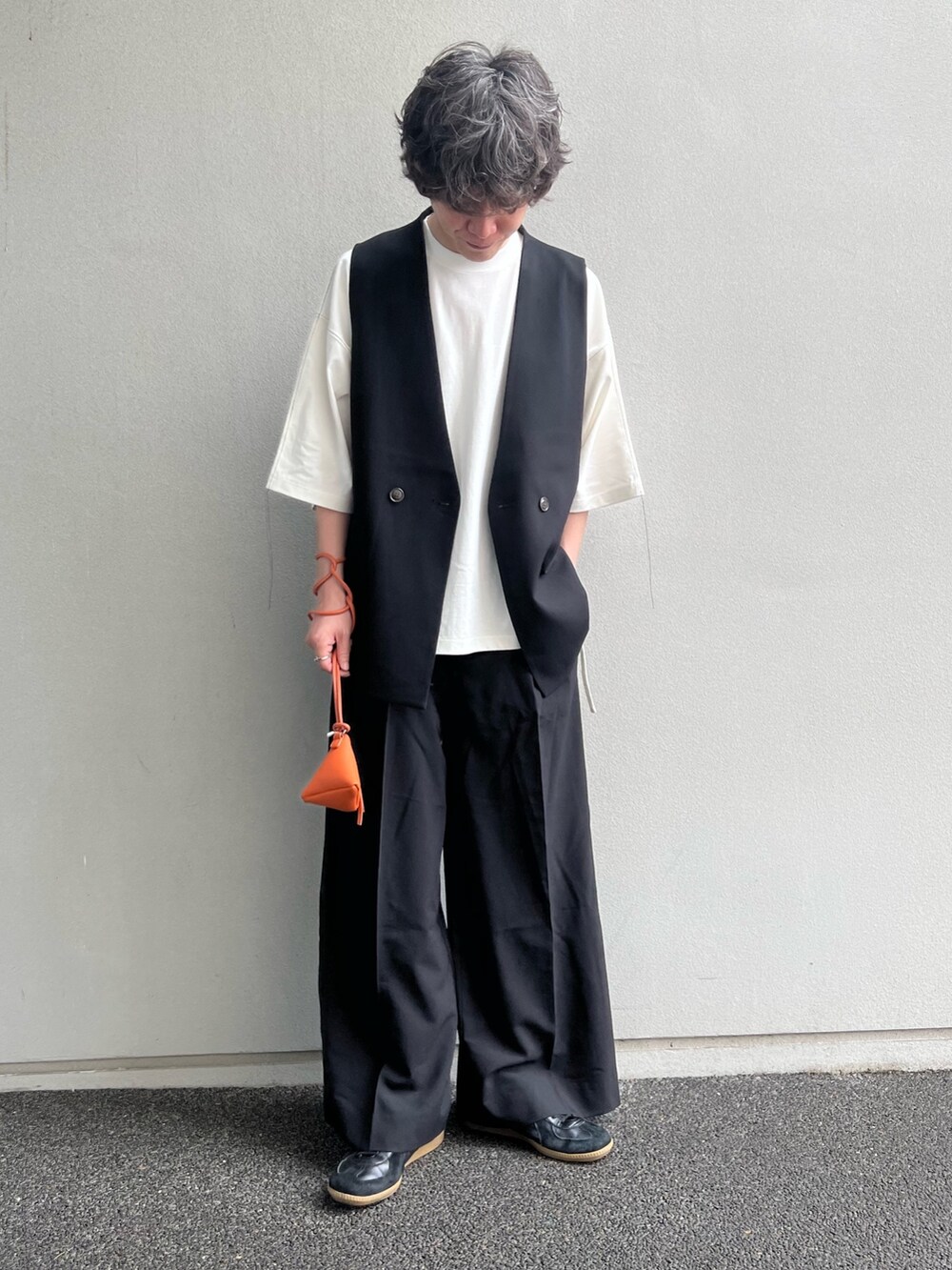 ブラック系のベスト、ホワイト系のTシャツ/カットソー、ブラック系のスラックスを着用したメンズの夏コーディネートの2枚目の写真