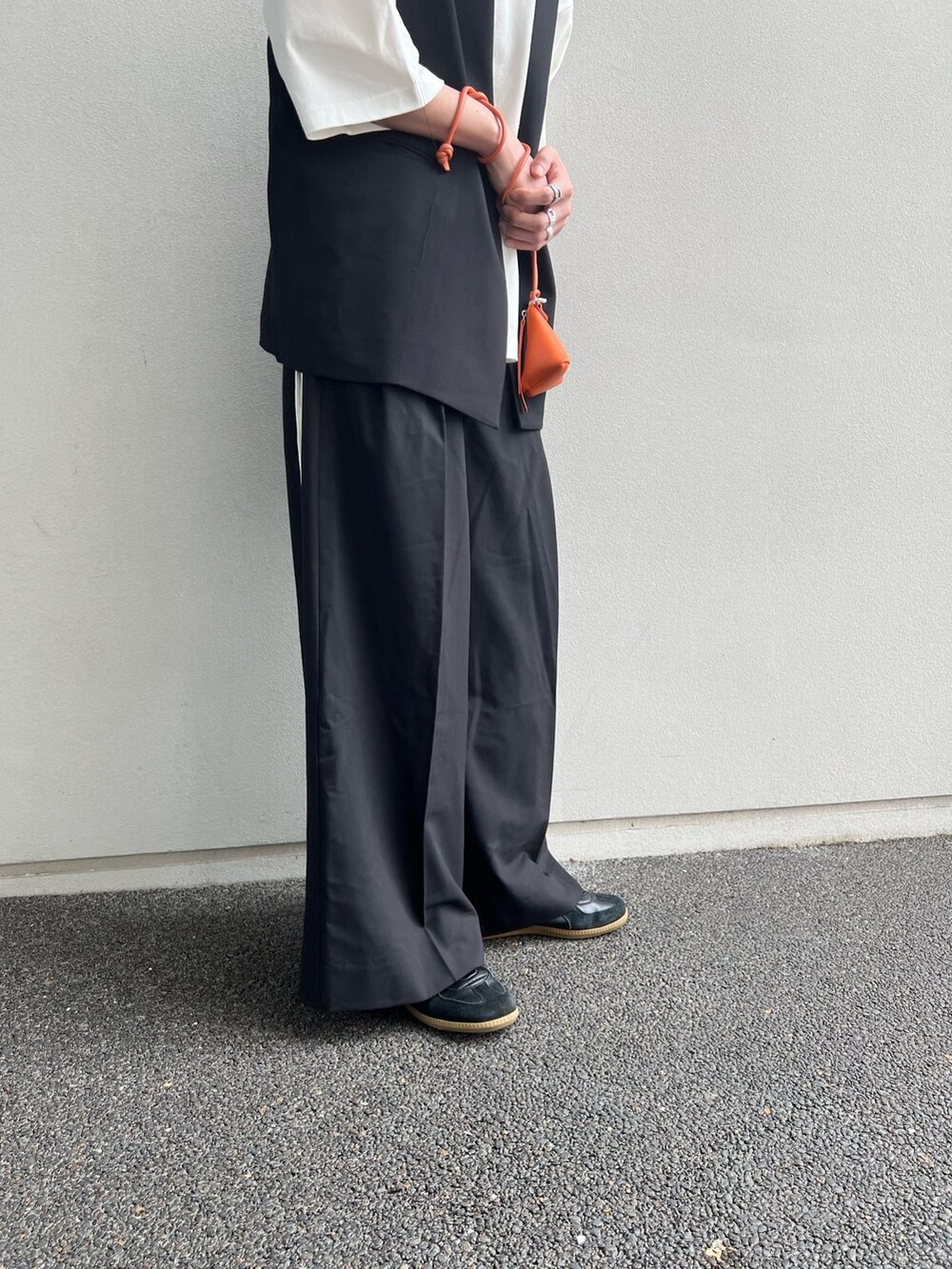 ブラック系のベスト、ホワイト系のTシャツ/カットソー、ブラック系のスラックスを着用したメンズの夏コーディネートの3枚目の写真