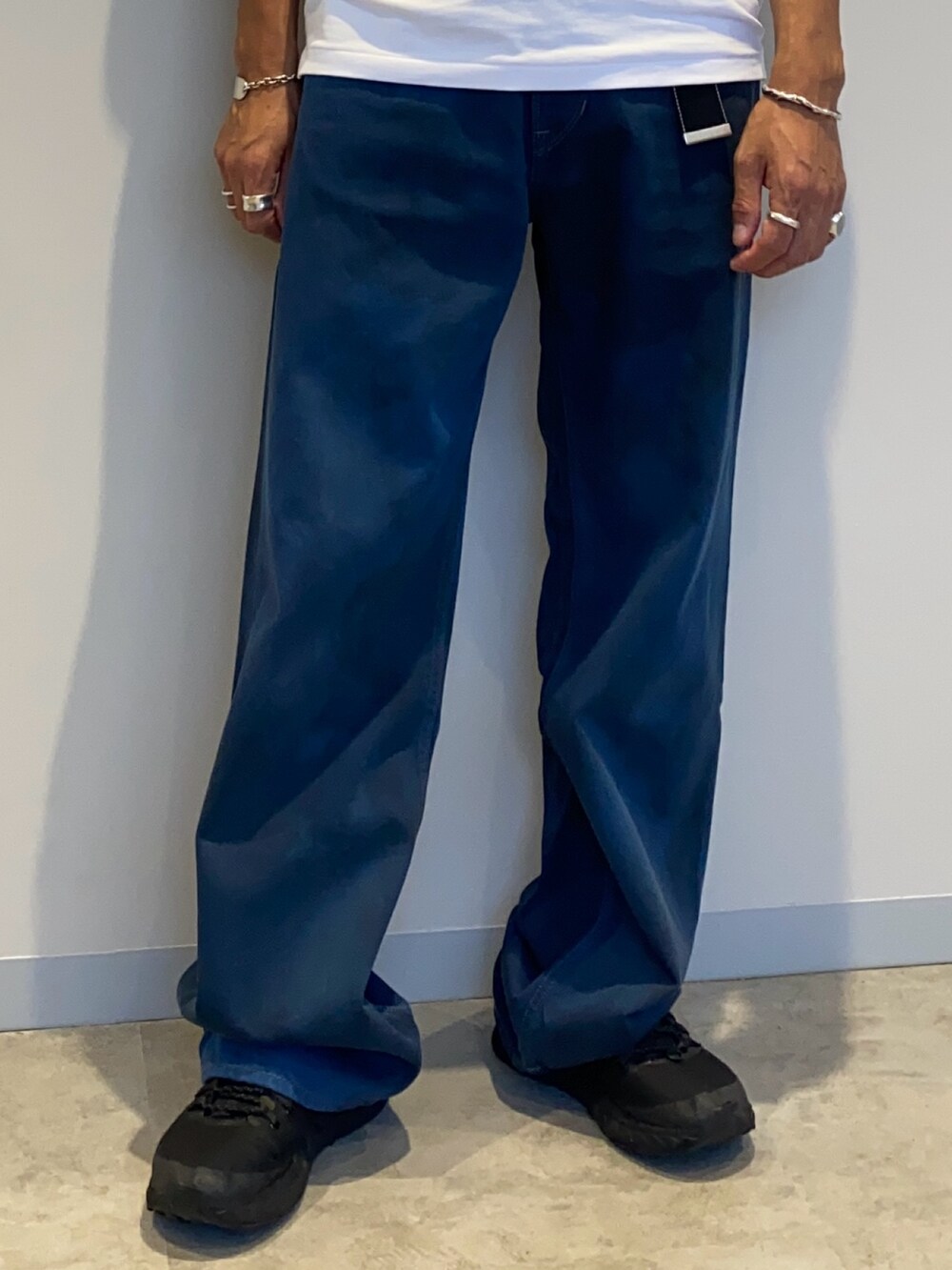 ホワイト系のポロシャツ、ブルー系のデニムパンツを着用したメンズの夏コーディネートの3枚目の写真