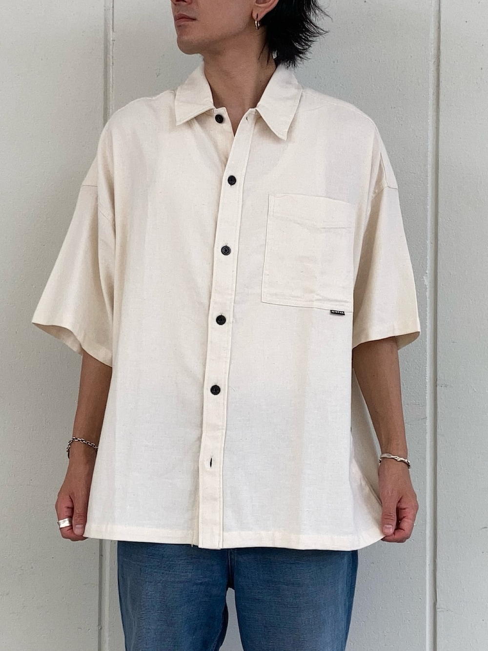 ベージュ系のシャツ/ブラウス、ブルー系のデニムパンツ、ブラウン系のベルトを着用したメンズの夏コーディネートの2枚目の写真
