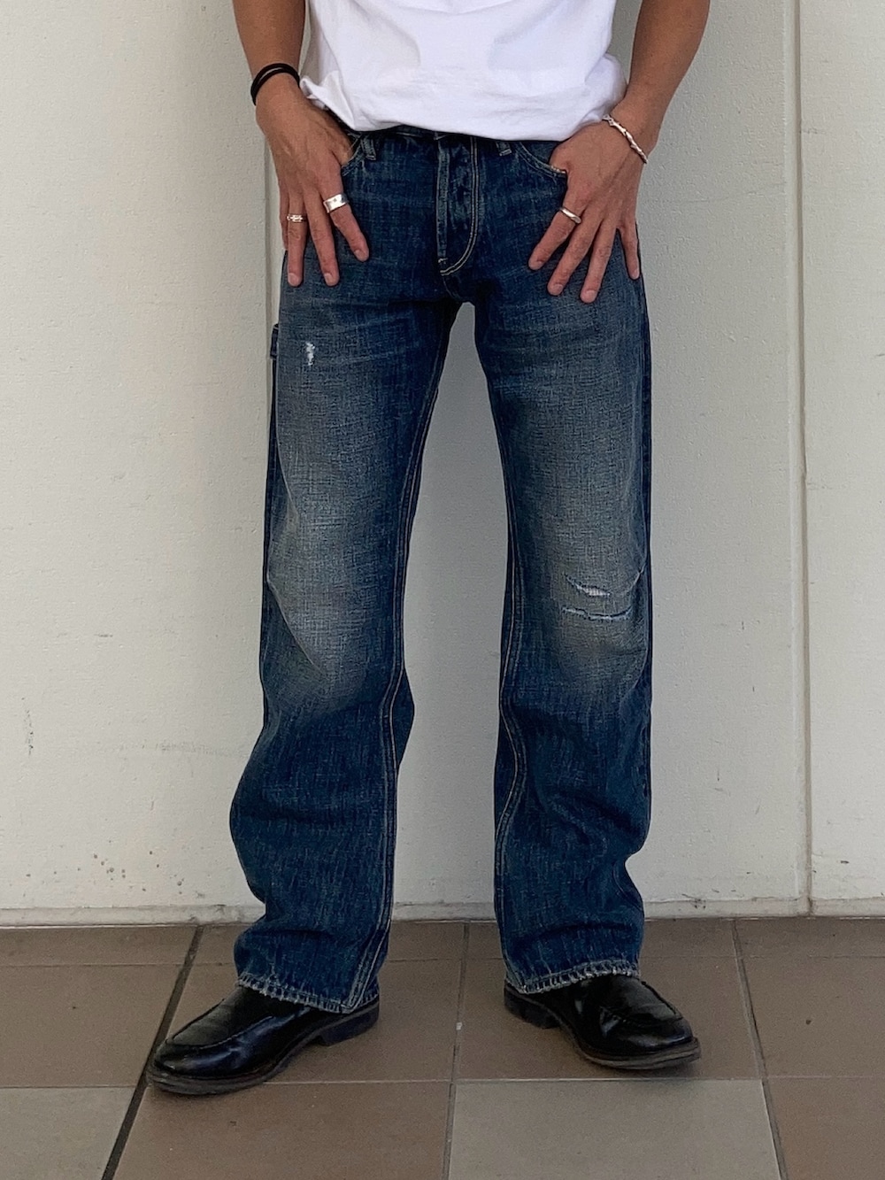 ブラック系のパーカー、ブルー系のデニムパンツ、ブラック系のブーツを着用したメンズの秋コーディネートの2枚目の写真