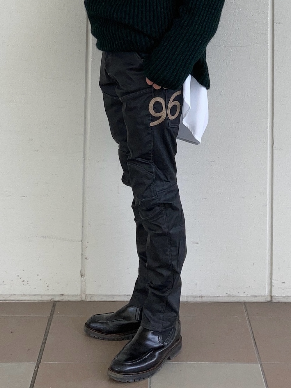 グレー系のブルゾン、グリーン系のニット/セーター、ホワイト系のシャツ/ブラウスを着用したメンズの冬コーディネートの3枚目の写真