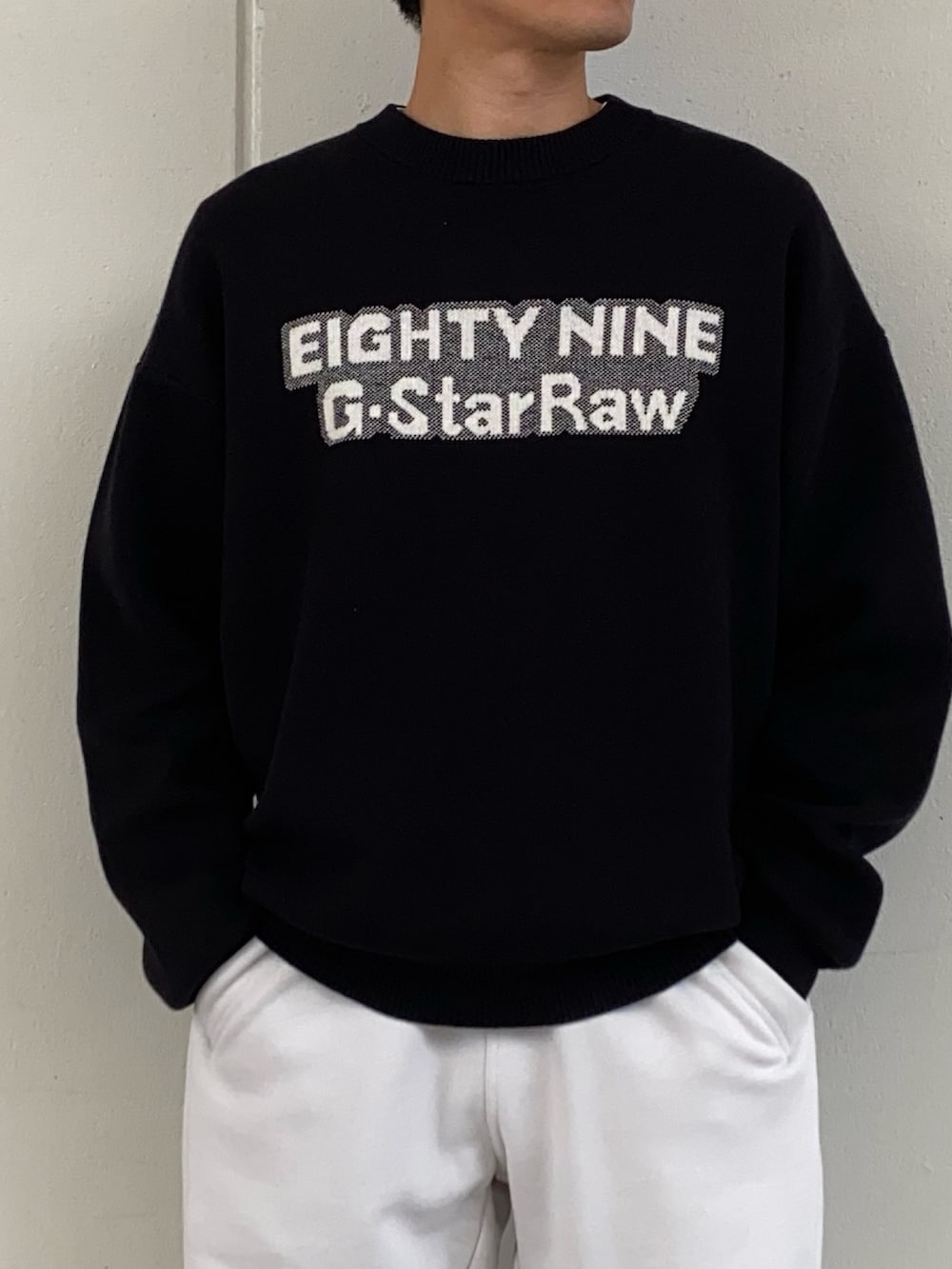 ブラック系のモッズコート、ブラック系のニット/セーター、グレー系のスウェットパンツを着用したメンズの秋コーディネートの2枚目の写真