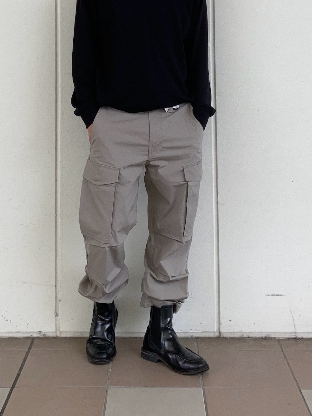 ブラック系のシャツ/ブラウス、ベージュ系のカーゴパンツ、ブラック系のブーツを着用したメンズの春コーディネートの2枚目の写真