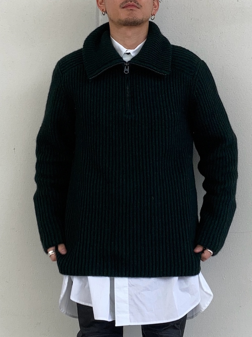 グレー系のブルゾン、グリーン系のニット/セーター、ホワイト系のシャツ/ブラウスを着用したメンズの冬コーディネートの2枚目の写真