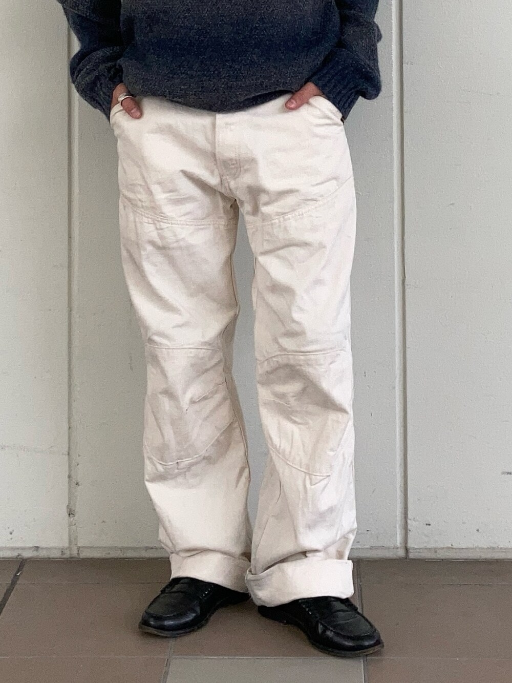 グレー系のデニムジャケット、ブルー系のニット/セーター、ベージュ系のデニムパンツを着用したメンズの秋コーディネートの3枚目の写真