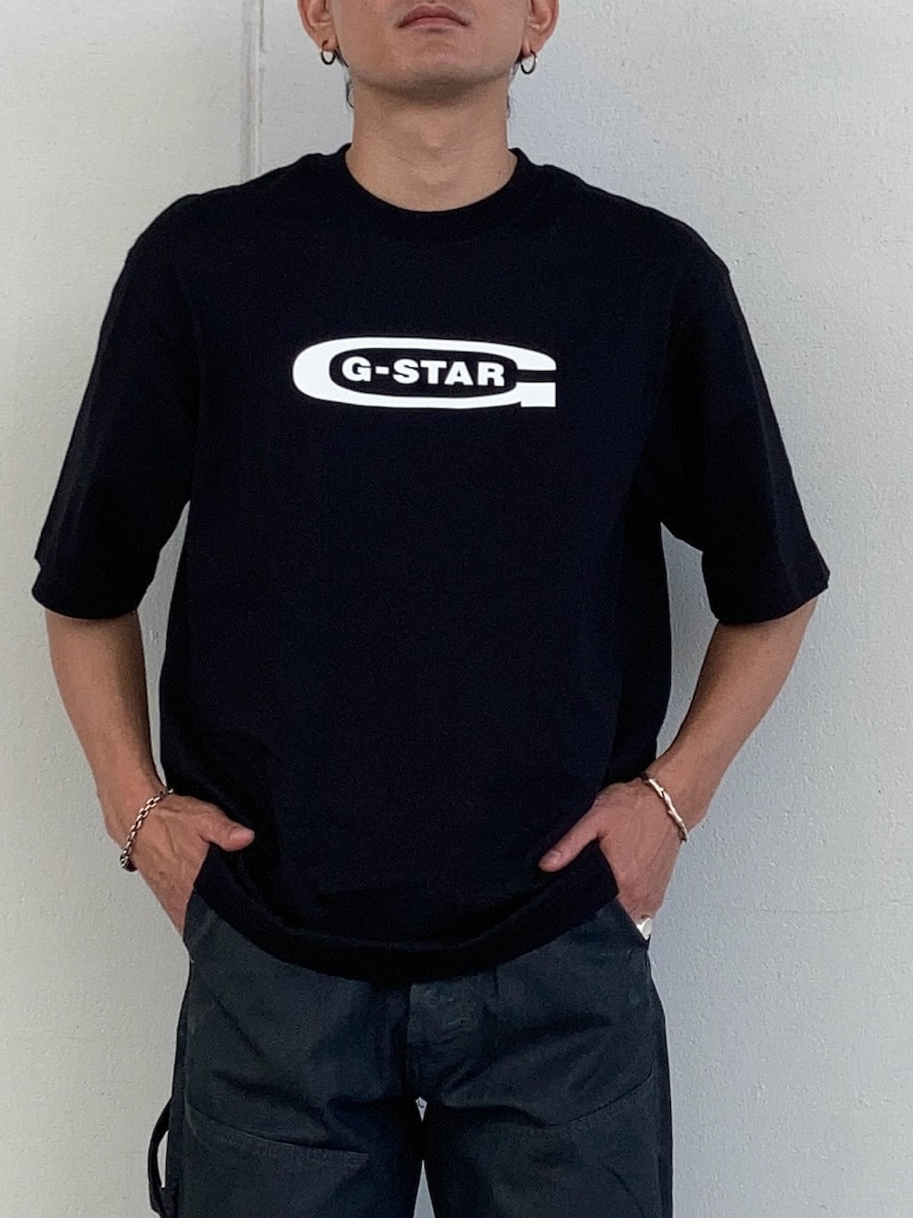 ブラック系のTシャツ/カットソー、ブラック系のデニムパンツ、ホワイト系のソックス/靴下を着用したメンズの夏コーディネートの2枚目の写真