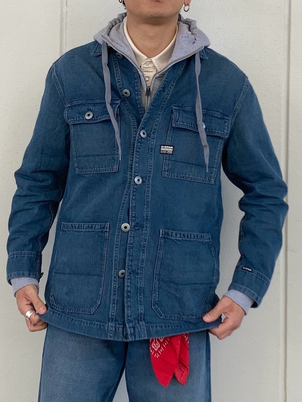 グレー系のパーカー、ブルー系のカバーオール、ブルー系のデニムパンツを着用したメンズの冬コーディネートの2枚目の写真