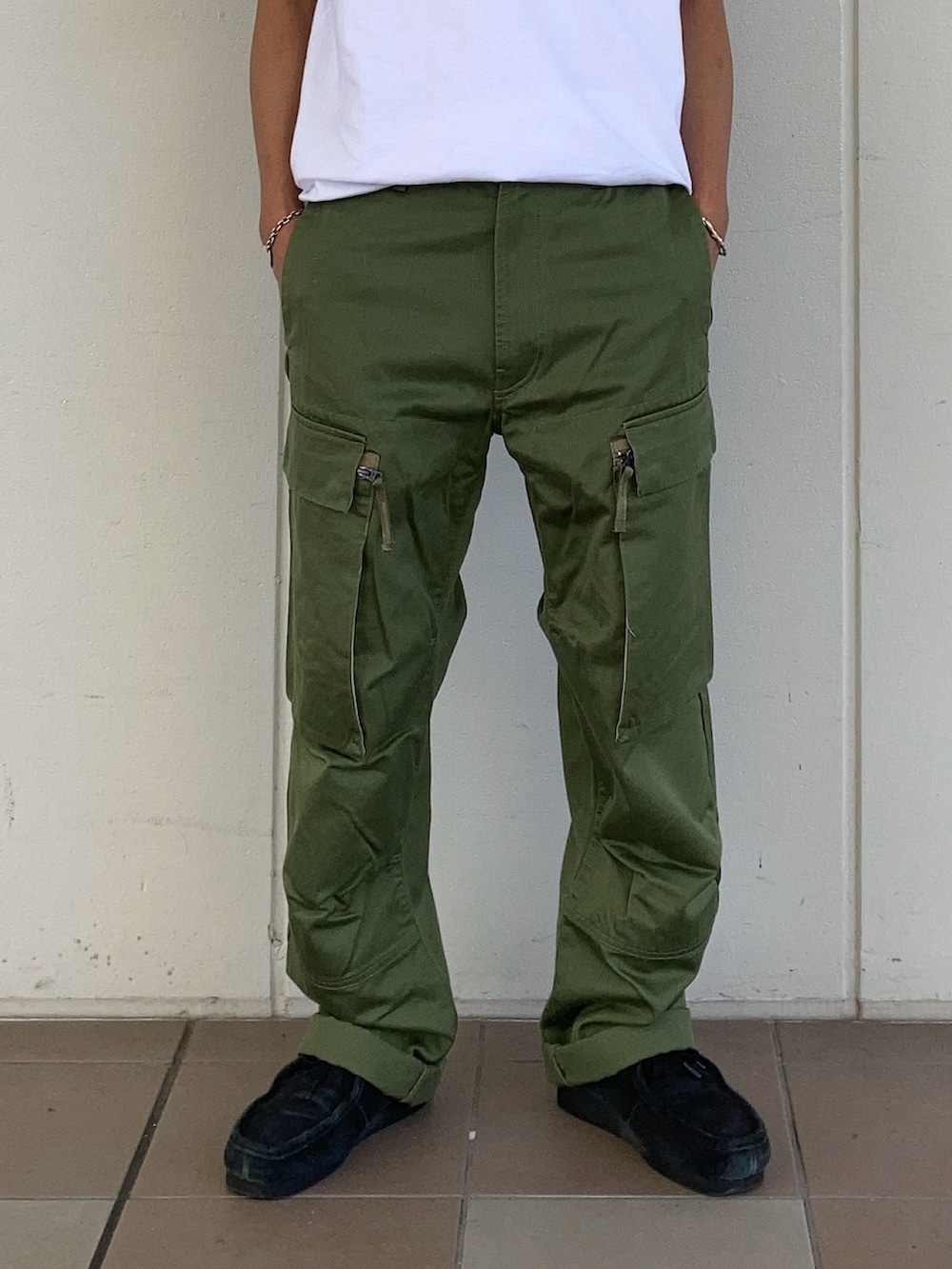 ホワイト系のTシャツ/カットソー、グリーン系のカーゴパンツ、ブラック系のソックス/靴下を着用したメンズの夏コーディネートの2枚目の写真