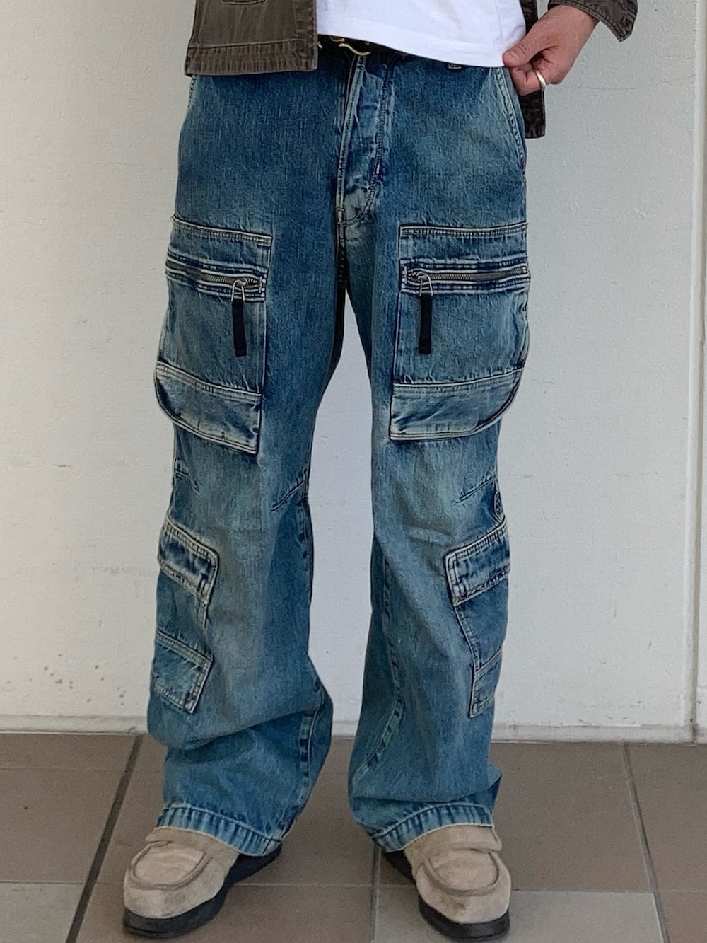 ベージュ系のミリタリージャケット、ブルー系のデニムパンツを着用したメンズの春コーディネートの3枚目の写真