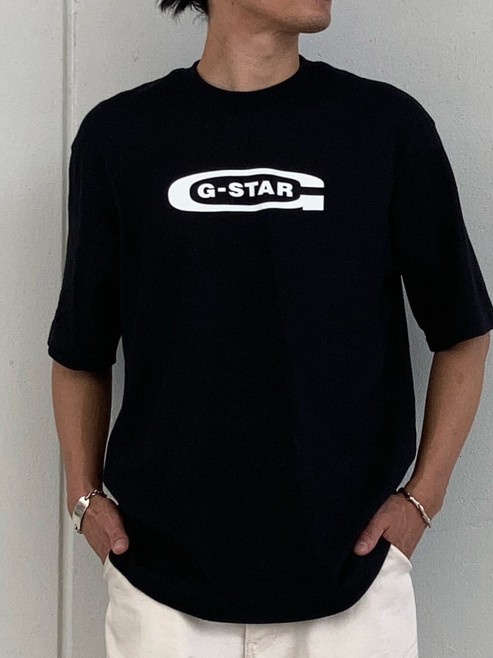 ブラック系のTシャツ/カットソー、ベージュ系のデニムパンツ、ブラック系のソックス/靴下を着用したメンズの夏コーディネートの2枚目の写真