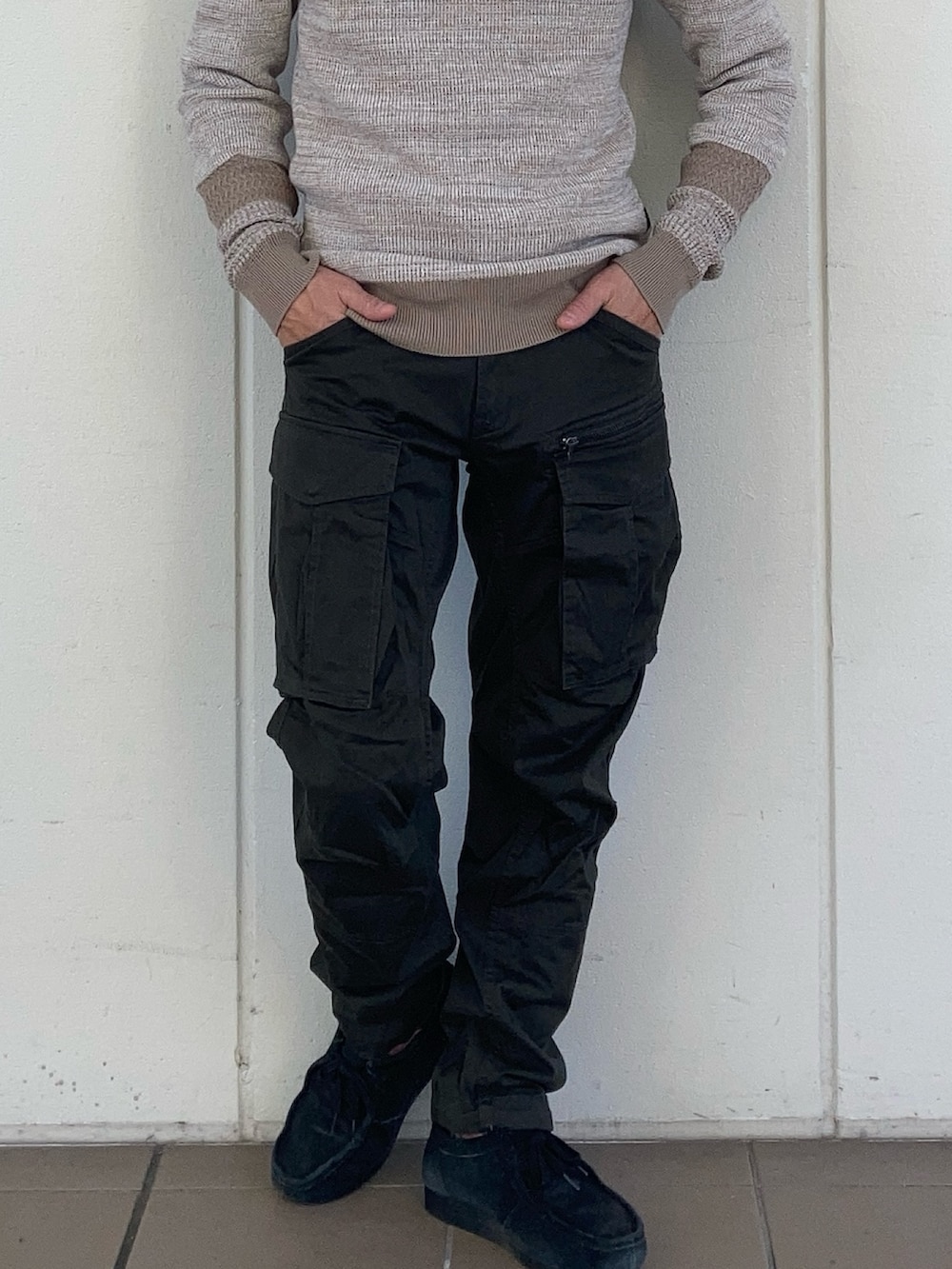 ブラック系のダウンジャケット/コート、グリーン系のカーゴパンツ、ベージュ系のニット/セーターを着用したメンズの秋コーディネートの4枚目の写真