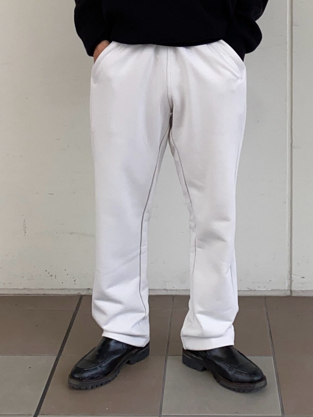 ブラック系のモッズコート、ブラック系のニット/セーター、グレー系のスウェットパンツを着用したメンズの秋コーディネートの3枚目の写真