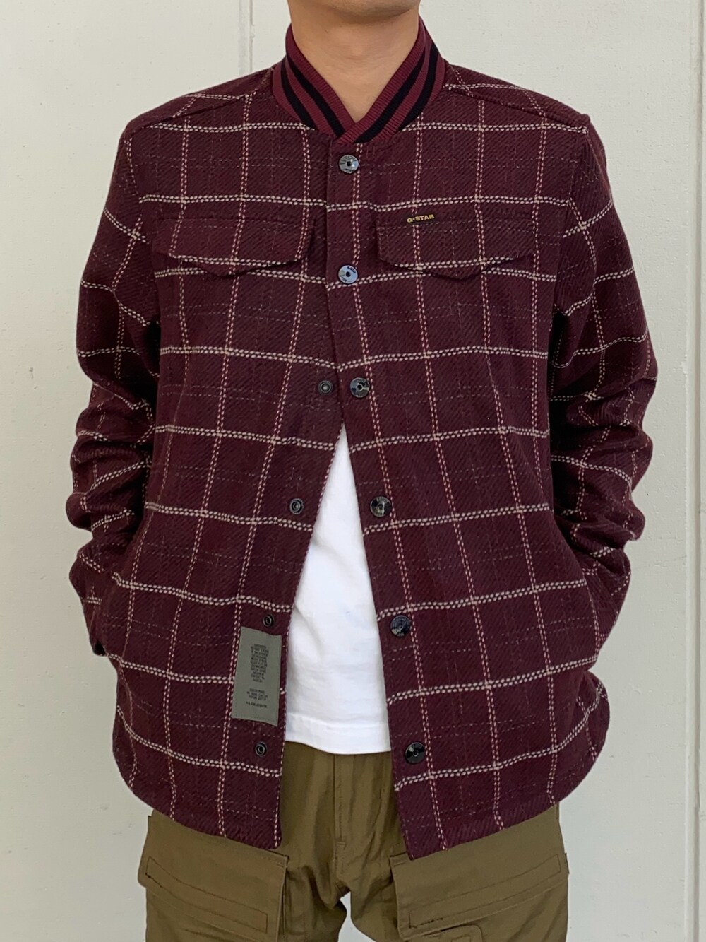 レッド系のブルゾン、グリーン系のカーゴパンツを着用したメンズの秋コーディネートの2枚目の写真