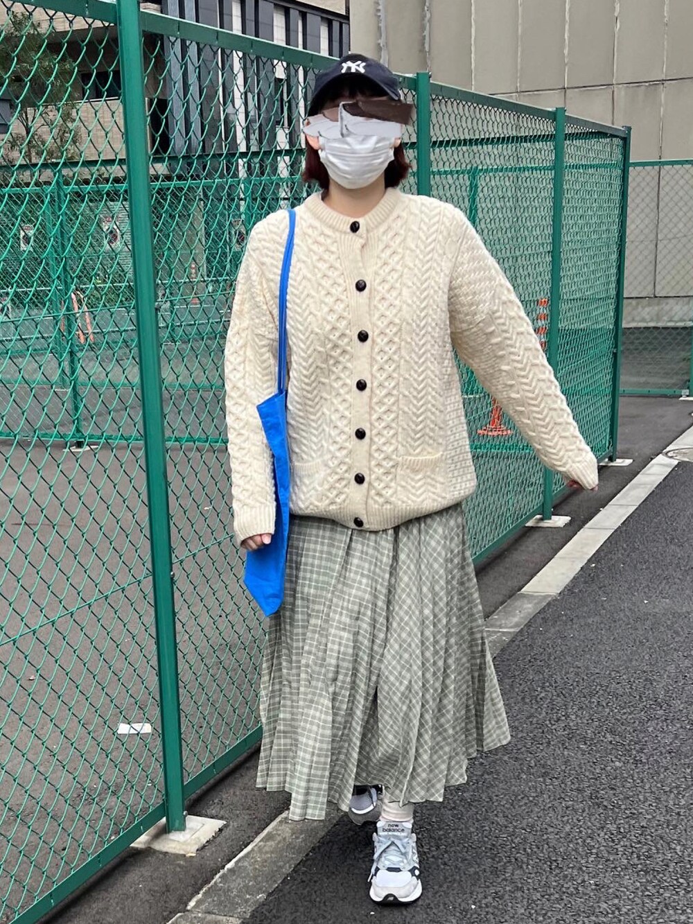 ベージュ系のカーディガン/ボレロ、グリーン系のスカート、グレー系のスニーカーを着用したレディースの春コーディネートの3枚目の写真