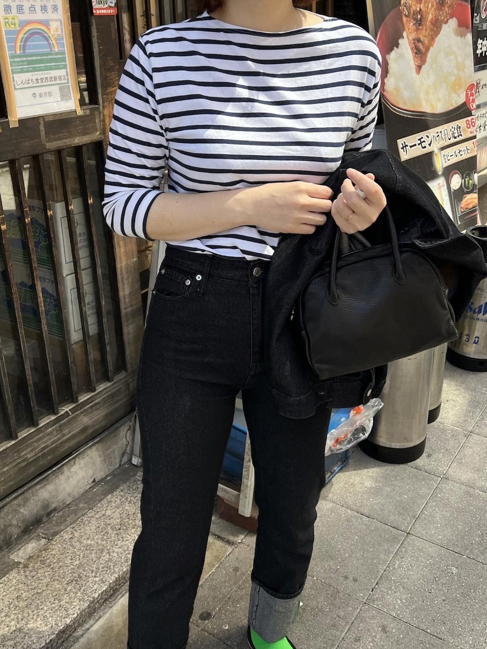 ブラック系のデニムジャケット、ブラック系のバレエシューズ、ブラック系のデニムパンツを着用したレディースの春コーディネートの3枚目の写真