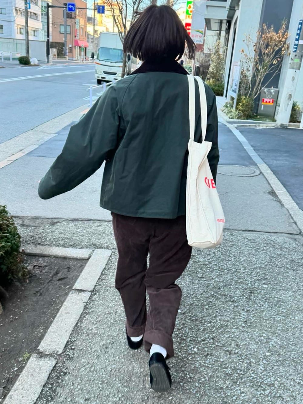ブラウン系のパンツ、ブラック系のその他シューズ、グリーン系のブルゾンを着用したレディースの春コーディネートの3枚目の写真