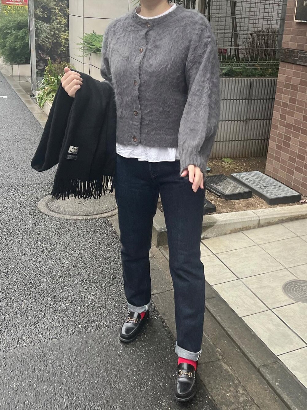 グレー系のカーディガン/ボレロ、ブルー系のデニムパンツ、ブラック系のローファーを着用したレディースの秋コーディネートの2枚目の写真