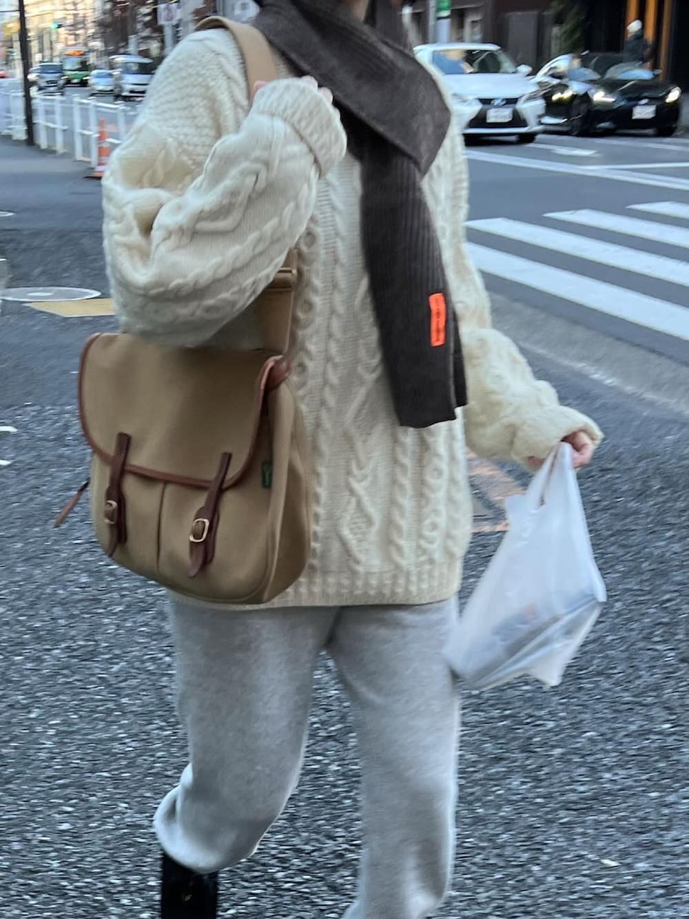 ベージュ系のショルダーバッグ、グレー系のスウェットパンツ、ブラック系のモカシン/デッキシューズを着用したレディースの冬コーディネートの3枚目の写真