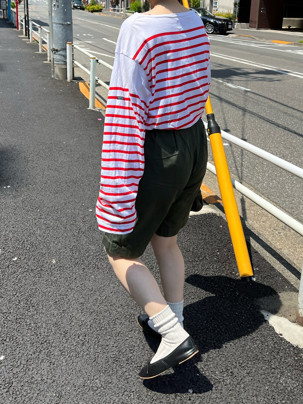 グリーン系のパンツ、ブラック系のボストンバッグ、ブラック系のバレエシューズを着用したレディースの春コーディネートの5枚目の写真
