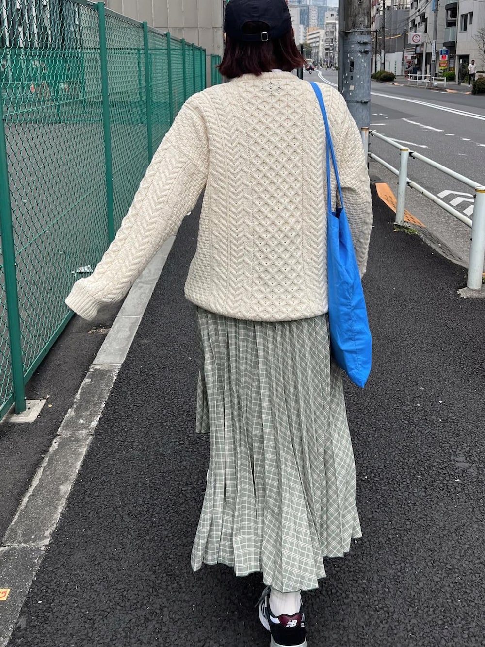 ベージュ系のカーディガン/ボレロ、グリーン系のスカート、グレー系のスニーカーを着用したレディースの春コーディネートの4枚目の写真