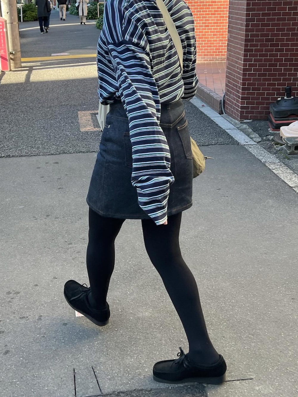 グリーン系のモッズコート、ブラック系のモカシン/デッキシューズ、ブルー系のスカートを着用したレディースの秋コーディネートの5枚目の写真