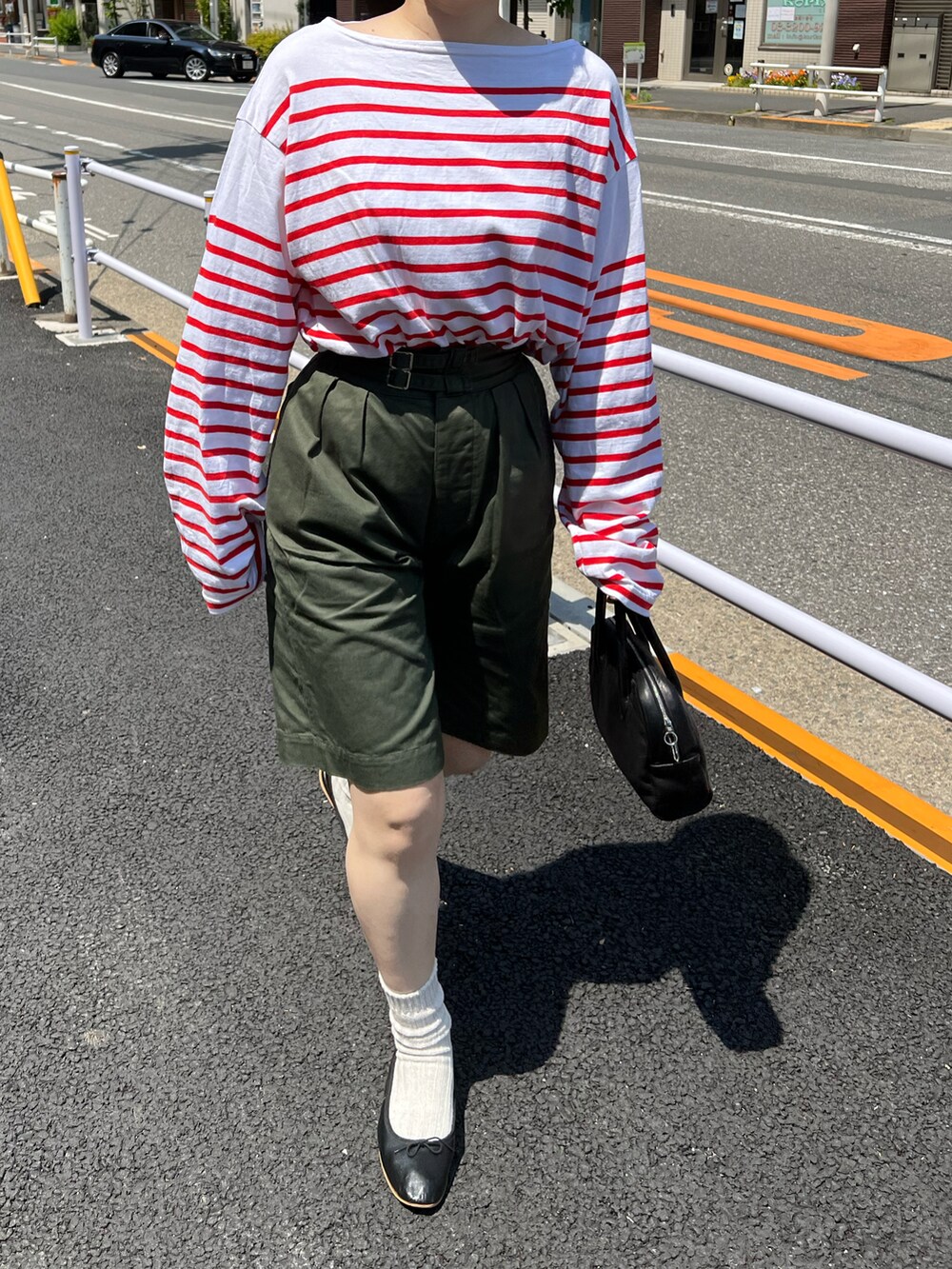 グリーン系のパンツ、ブラック系のボストンバッグ、ブラック系のバレエシューズを着用したレディースの春コーディネートの3枚目の写真