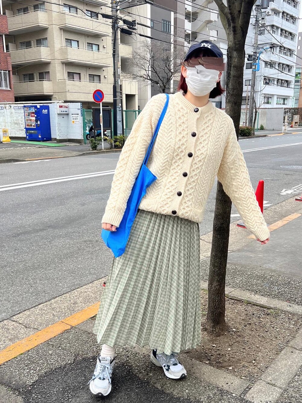 ベージュ系のカーディガン/ボレロ、グリーン系のスカート、グレー系のスニーカーを着用したレディースの春コーディネートの2枚目の写真