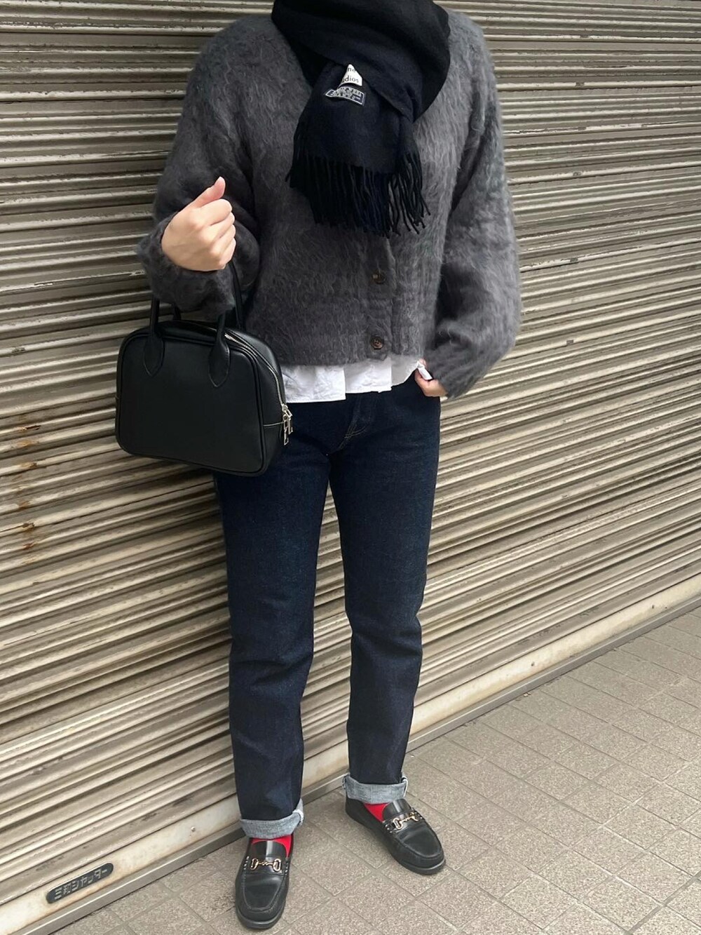 グレー系のカーディガン/ボレロ、ブルー系のデニムパンツ、ブラック系のローファーを着用したレディースの秋コーディネートの3枚目の写真