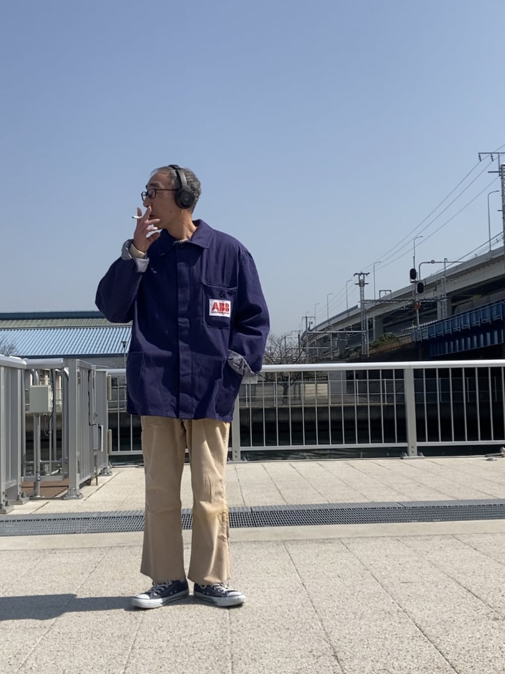 ブルー系のデニムジャケット、ベージュ系のパンツ、ブルー系のスニーカーを着用したメンズの春コーディネートの2枚目の写真