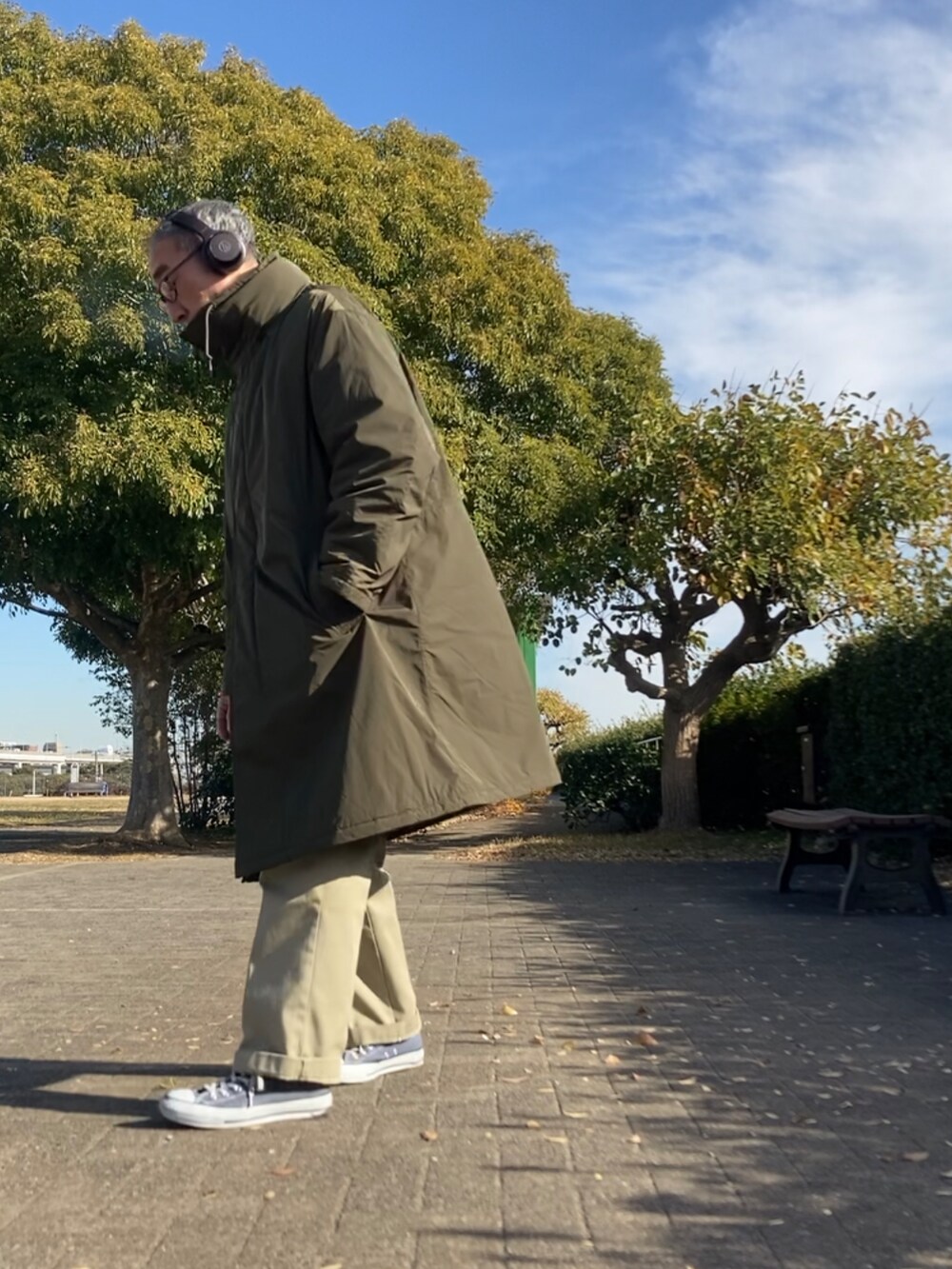ベージュ系のダウンジャケット/コート、ベージュ系のチノパンツ、ブルー系のスニーカーを着用したメンズの冬コーディネートの2枚目の写真
