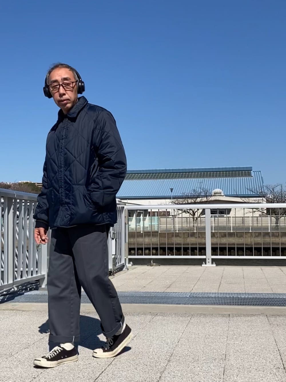 ブルー系のその他アウター、グレー系のチノパンツ、ブラック系のスニーカーを着用したメンズの春コーディネートの2枚目の写真