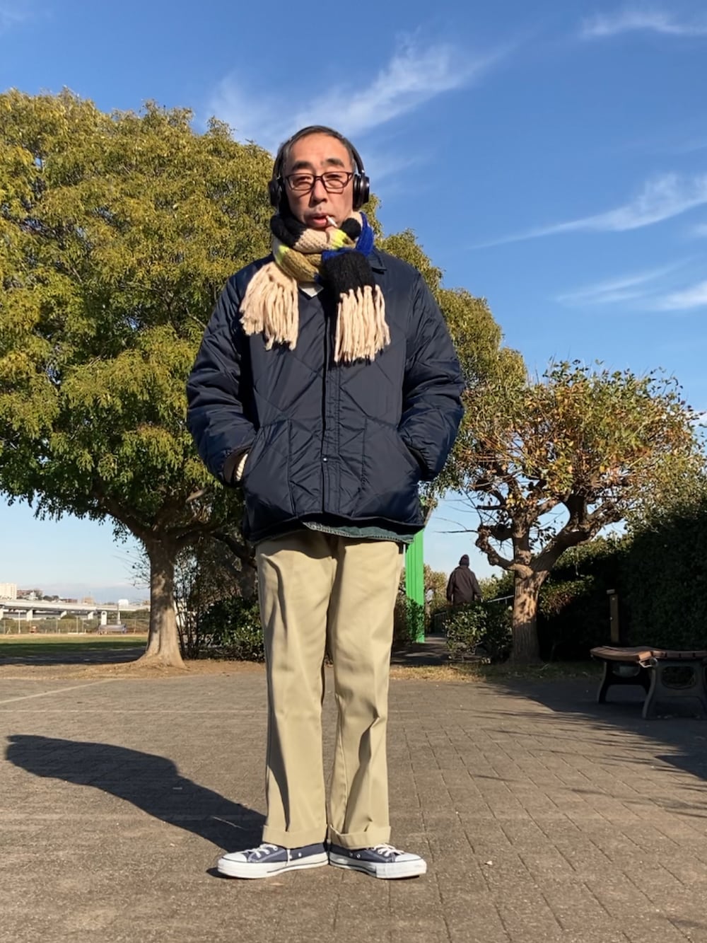 ブルー系のその他アウター、ベージュ系のチノパンツ、ブルー系のスニーカーを着用したメンズの冬コーディネートの2枚目の写真
