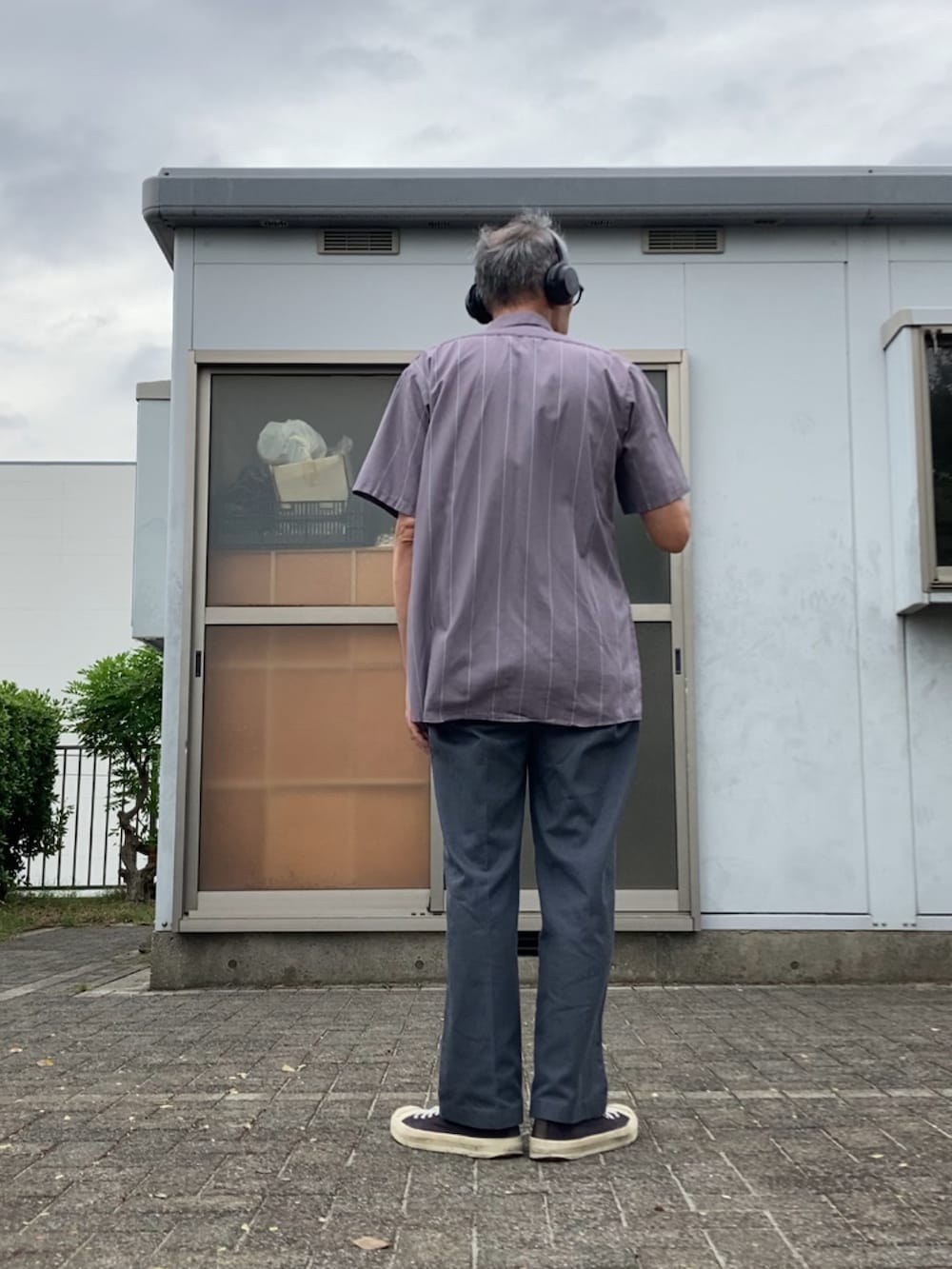 グレー系のシャツ/ブラウス、グレー系のチノパンツ、ブラック系のスニーカーを着用したメンズの秋コーディネートの2枚目の写真