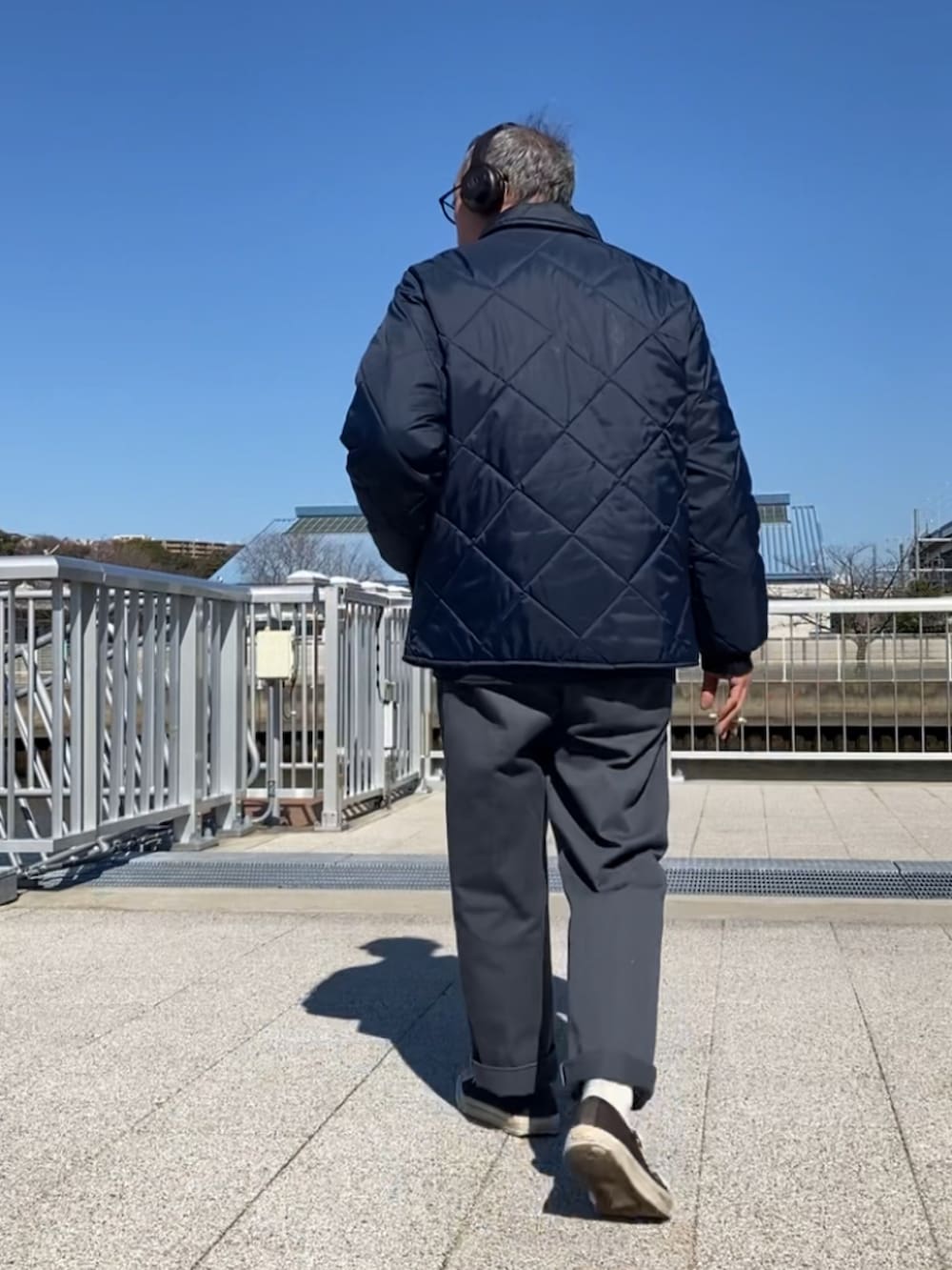 ブルー系のその他アウター、グレー系のチノパンツ、ブラック系のスニーカーを着用したメンズの春コーディネートの3枚目の写真