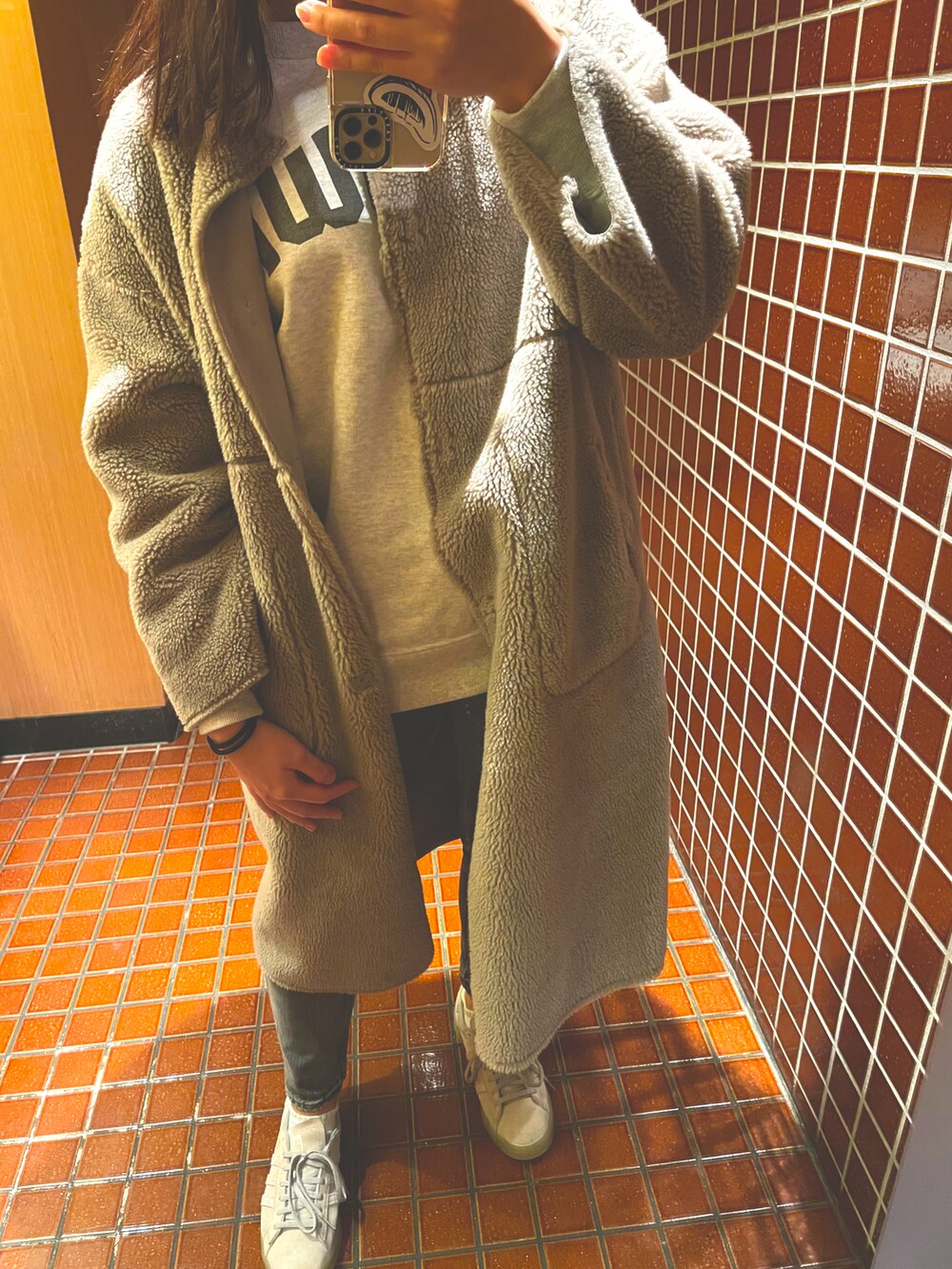 グレー系のスニーカー、グレー系のムートンコート、グレー系のスウェットを着用したレディースの秋コーディネートの2枚目の写真
