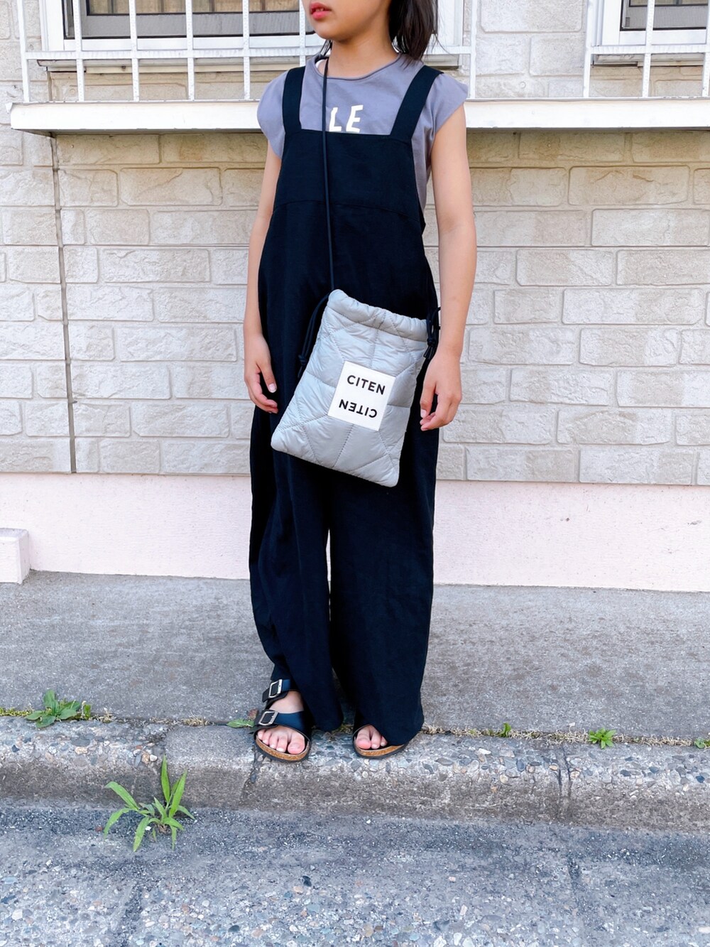 グレー系のショルダーバッグ、グレー系のTシャツ/カットソー、ピンク系のスニーカーを着用したキッズの夏コーディネートの2枚目の写真
