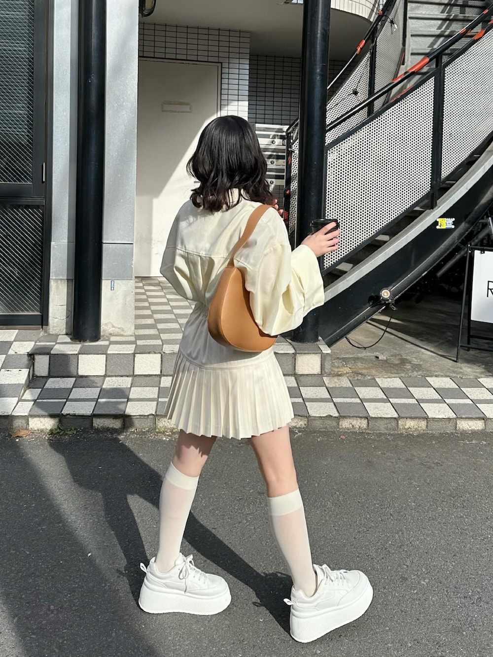 イエロー系のシャツ/ブラウス、ホワイト系のスカート、ホワイト系のスニーカーを着用したレディースの冬コーディネートの2枚目の写真