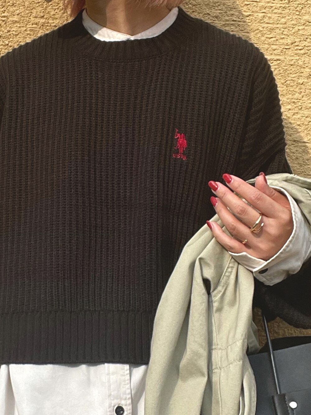 ブラック系のニット/セーター、ベージュ系のスウェットパンツ、ブラック系のブーツを着用したレディースの秋コーディネートの3枚目の写真