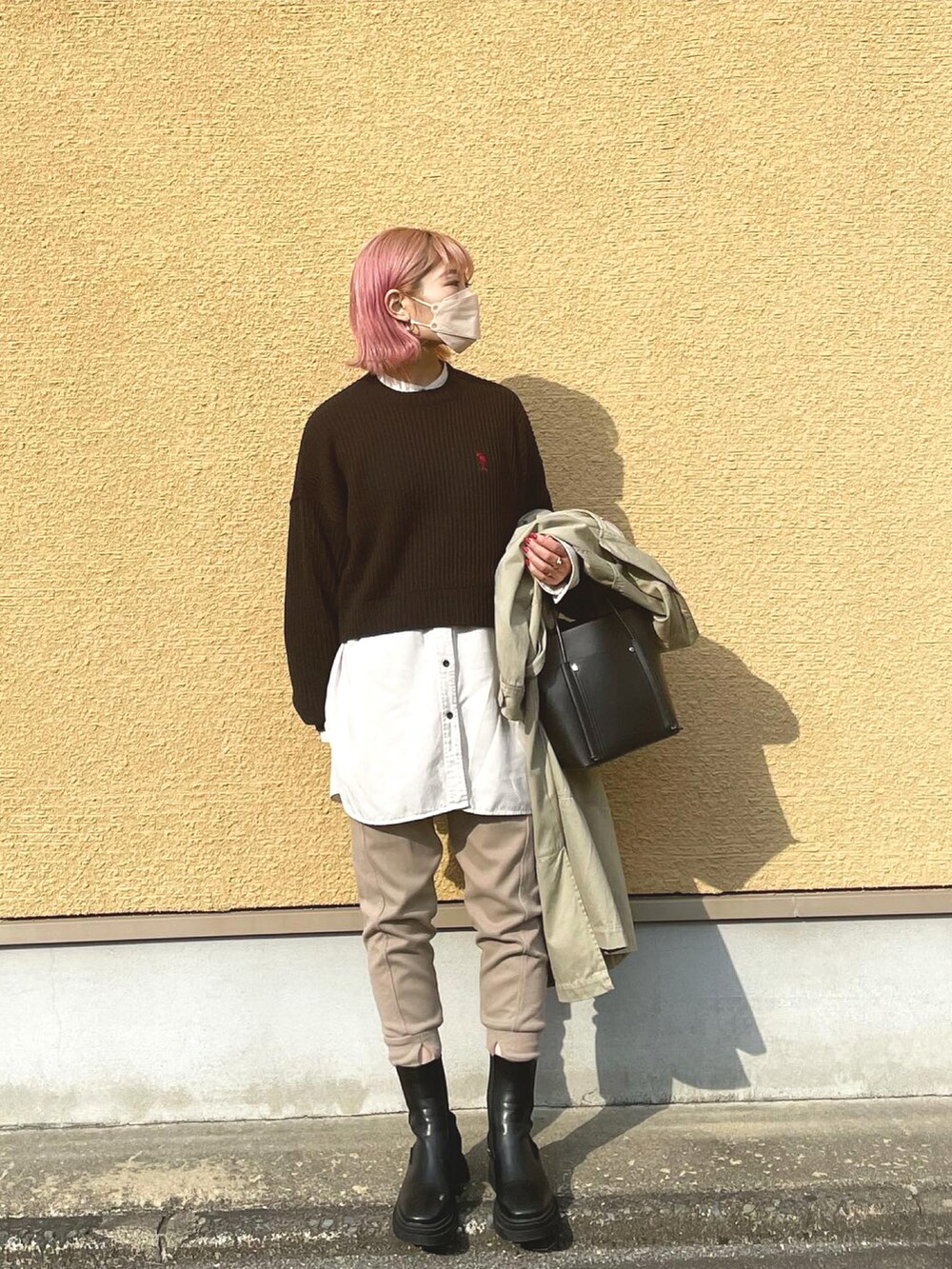 ブラック系のニット/セーター、ベージュ系のスウェットパンツ、ブラック系のブーツを着用したレディースの秋コーディネートの2枚目の写真