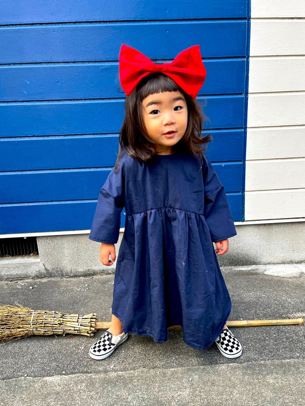 ブルー系のワンピース、その他のスリッポン、レッド系のヘアバンドを着用したキッズの秋コーディネートの2枚目の写真