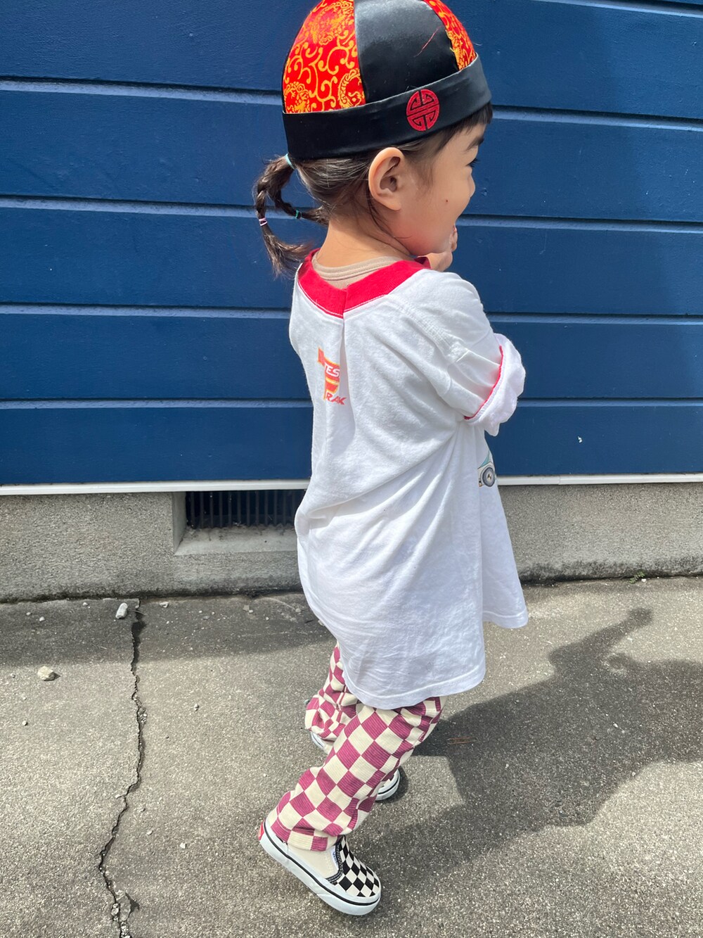 ホワイト系のTシャツ/カットソー、レッド系のその他パンツ、その他のスリッポンを着用したキッズの秋コーディネートの2枚目の写真