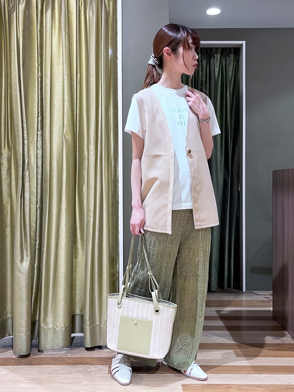 ベージュ系のベスト、ホワイト系のTシャツ/カットソー、ホワイト系のサンダルを着用したレディースの春コーディネートの3枚目の写真