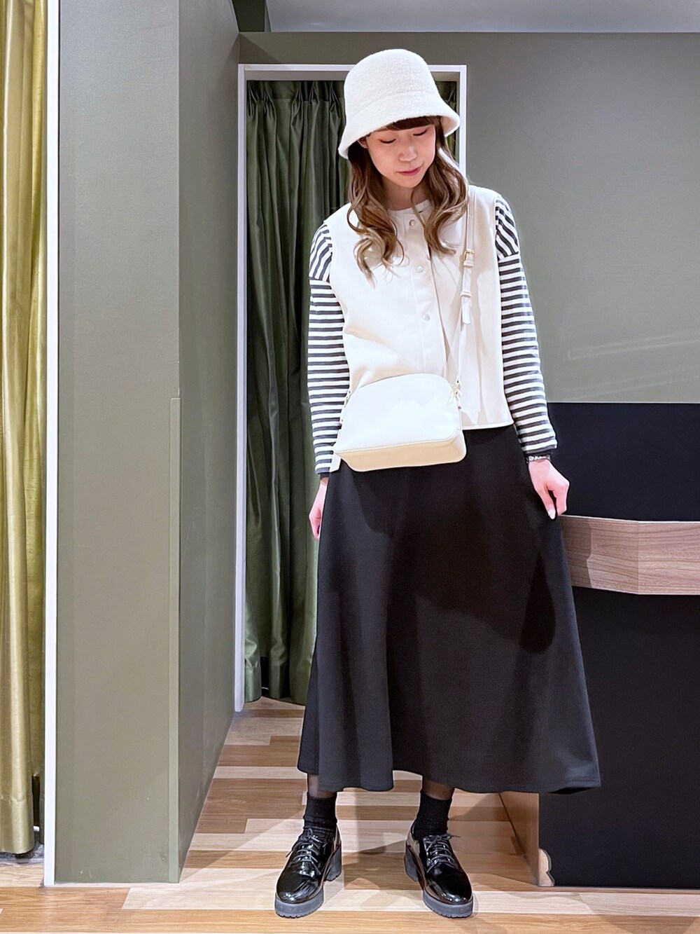 グレー系のTシャツ/カットソー、ホワイト系のトートバッグ、ベージュ系のベストを着用したレディースの冬コーディネートの3枚目の写真